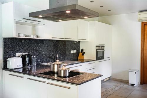 a kitchen with white cabinets and a counter top at Utalay Koh Chang Villas in Ko Chang