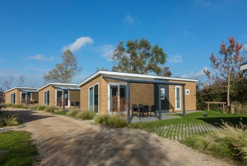 a row of modular homes with a driveway at Welcome in - Vakantiepark Fort den Haak - 2 huisdieren toegestaan - Dichtbij strand en Veerse Meer in Vrouwenpolder