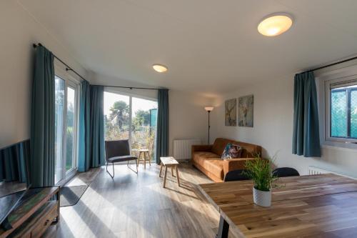 a living room with a couch and a table at Welcome in - Vakantiepark Fort den Haak I Nabij strand en Veerse meer in Vrouwenpolder