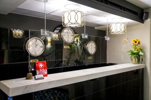 a room with clocks on the wall and a counter at Casa Malí by Dominion Boutique Hotel in Mexico City
