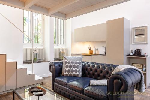 a living room with a leather couch and a table at Golden Prestige in Milan