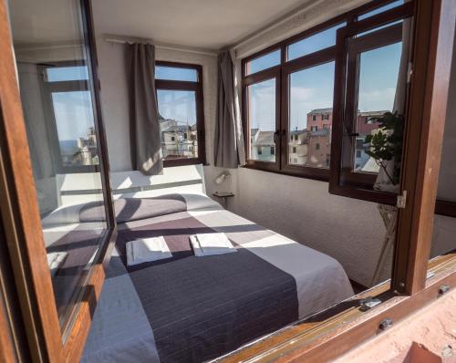 ヴェルナッツァにあるLa Torretta dei Merli with Viewsの窓付きの部屋にベッド付きのベッドルーム1室があります。