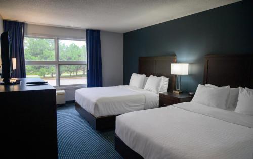 a hotel room with two beds and a window at Days Inn by Wyndham Sarnia Harbourfront in Sarnia