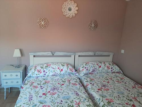 a bedroom with a bed and a nightstand and two clocks at Hospital del Temple Casa Rural in Boquiñeni