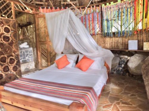 a bedroom with a bed with a mosquito net at Eco Hostal Yuluka in El Zaino