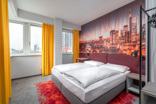 a bedroom with a bed and a painting on the wall at Campanile Frankfurt Offenbach in Offenbach