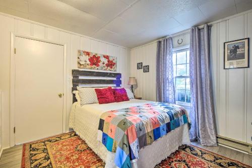 a bedroom with a bed with a colorful comforter and a window at Homey Horse Farm Hideaway about 6 Mi to KY Horse Park! in Lexington