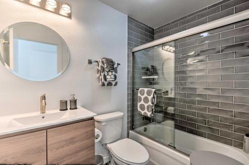a bathroom with a toilet and a sink and a mirror at Modern Midtown Haven with Garage Mt Rose Day Trips! in Reno