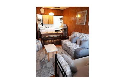 uma sala de estar com um sofá e uma mesa em Residence Bellevue - maeva Home em Orcières
