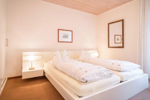 two beds in a white room with two lamps at Rosenblüte in Lindau