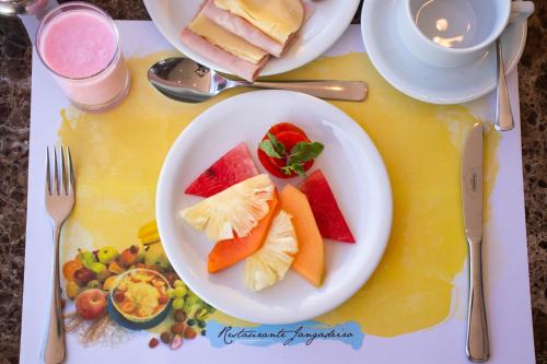 a white plate of fruit on a table at Hotel Beira Mar in Fortaleza