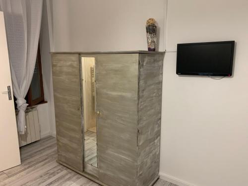 a large metal cabinet with a tv on a wall at hôtel Le Cosy in Pont-de-Chéruy