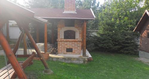 a small brick dog house in a yard at Dudás panzió in Bükkszentkereszt