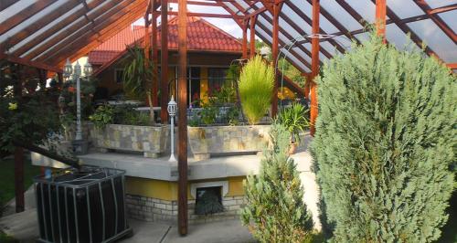 un jardín con chimenea de piedra en un invernadero en Dudás panzió en Bükkszentkereszt