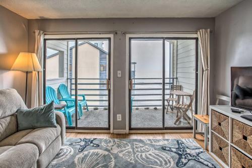 ein Wohnzimmer mit einem Sofa und einer Glasschiebetür in der Unterkunft Cozy Beachfront Condo with WiFi, Views and Pool Access in Myrtle Beach