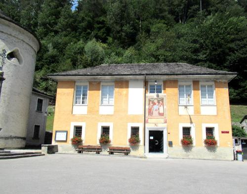 a building with two benches in front of it at Casa Marco in Brione