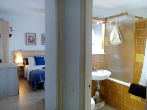 a bedroom with a bed and a bathroom with a sink at Apartamento San Agustín in Córdoba