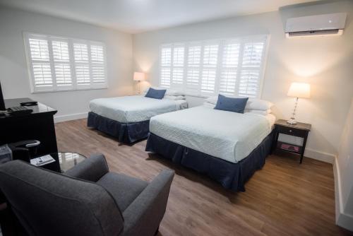 Zimmer mit 2 Betten, einem Stuhl und einem Sofa in der Unterkunft The Drift Hotel in Fort Lauderdale