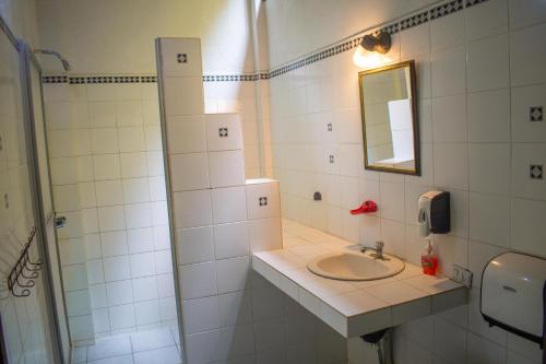 a bathroom with a sink and a mirror at Hostel Plinio in Manuel Antonio