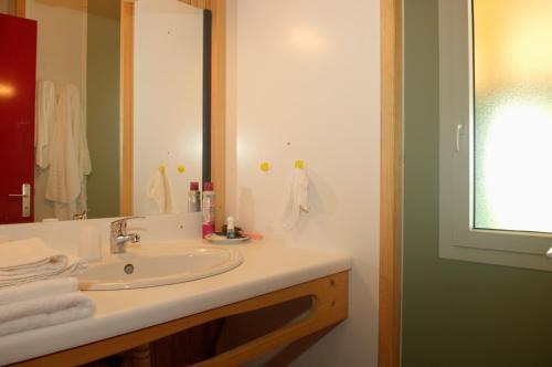une salle de bain avec un lavabo et un miroir dans l'établissement Azureva Vendée Océan, à Longeville-sur-Mer