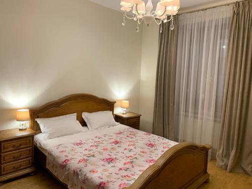 Schlafzimmer mit einem Bett und einem Kronleuchter in der Unterkunft Апартаменти у серці Львова in Lwiw