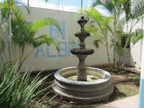 a fountain in the middle of a courtyard with palm trees at Hotel Albri by Rotamundos in Tecolutla