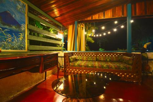 a couch and a table in a room with lights at Hotel La Mansion Inn Arenal in Nuevo Arenal