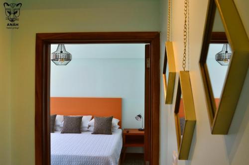 a bedroom with a bed and a mirror at Apartamentos el Prado en Zona 1 - ANAH hotel group in Guatemala
