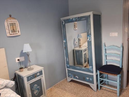 a blue cabinet with a mirror and a chair in a room at Casa rural "Garnacha de Borja" guest home in Borja