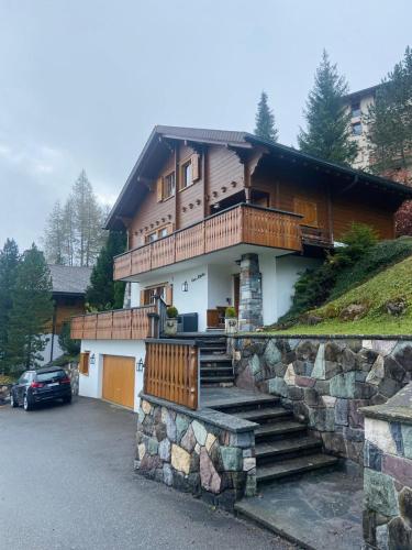a house with a stone wall and stairs in front at Casa Alpetta in Flumserberg