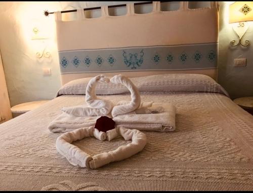 a bed with two swans made out of towels at Il Nuraghe del lago Coghinas in Oschiri