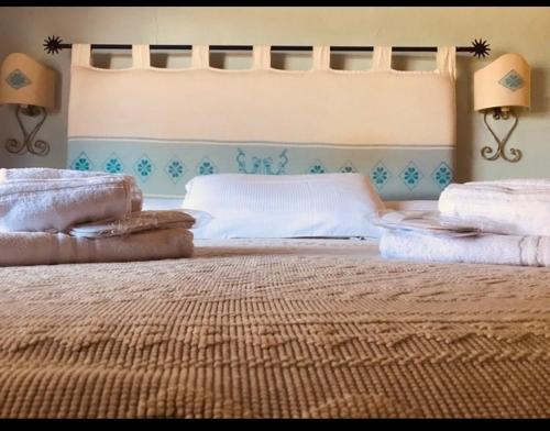 a bedroom with a large bed with towels on it at Il Nuraghe del lago Coghinas in Oschiri
