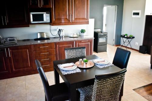 a kitchen with a table with chairs and a dining room at Aguia-Vista Couples Haven, Views, Pool, Beach Walk in Jeffreys Bay
