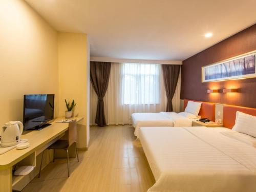 a hotel room with two beds and a desk at 7Days Inn Suzhou Park New Area Commercial Street in Suzhou