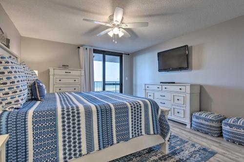 a bedroom with a bed with a ceiling fan and a television at Coastal Orange Beach Condo Resort and Beach Access! in Orange Beach