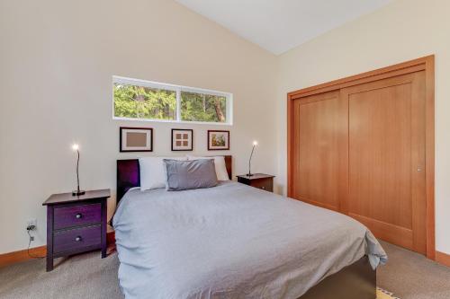 a bedroom with a large bed and a window at McKinnis Hill Cabin in Eastsound