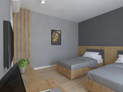 a small room with two beds and a tv at Zbruch Palace Hotel in Volochysk