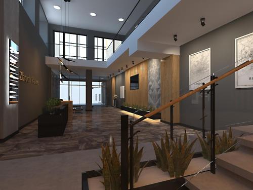 a lobby with stairs and plants in a building at Zbruch Palace Hotel in Volochysk