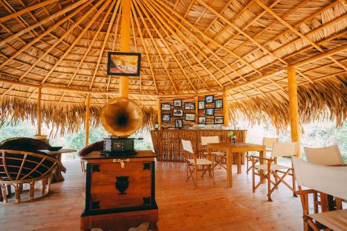 雅拉的住宿－Tribe Yala - Luxury Camping，配有桌椅和稻草屋顶的客房