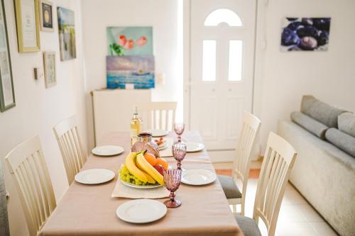a dining room table with a bowl of fruit on it at Aloe Villa Chania Crete in Georgioupolis