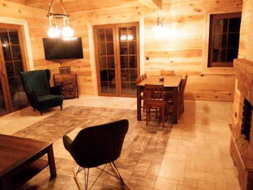 a living room with a table and chairs and a television at Chata Sosenka in Sygontka