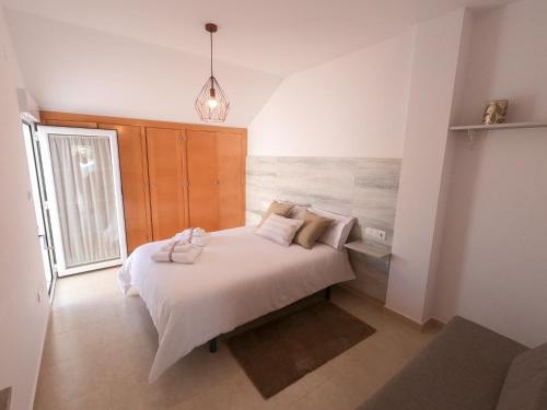 a bedroom with a bed with white sheets and pillows at ÁTICO ALTEA BLANCA in Altea