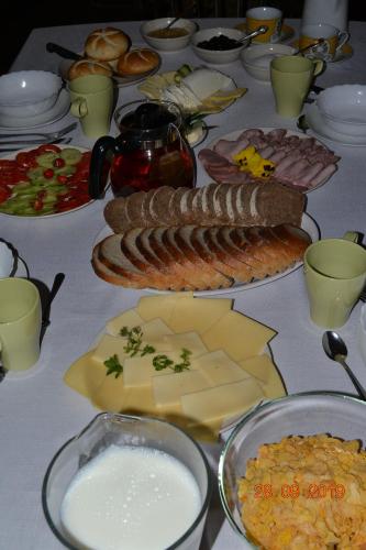 AGROTURYSTYKA TEOSIOWO في بوبيدنا: طاولة مليئة بالجبن واللحوم والأطعمة الأخرى