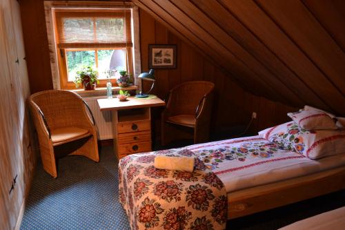 um quarto com uma cama, uma secretária e uma janela em AGROTURYSTYKA TEOSIOWO em Pobiedna