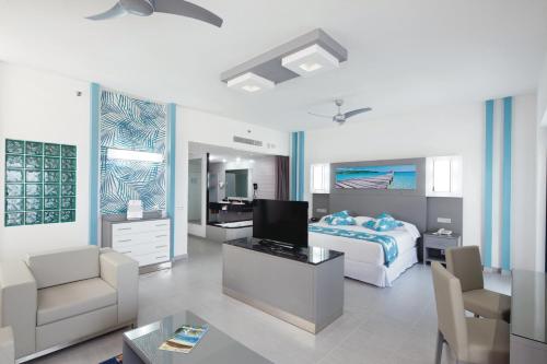 a bedroom with a bed and a living room at Riu Playa Blanca - All Inclusive in Playa Blanca