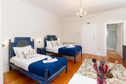 two beds in a room with blue and white at Quinta Das Murtas B&B in Sintra