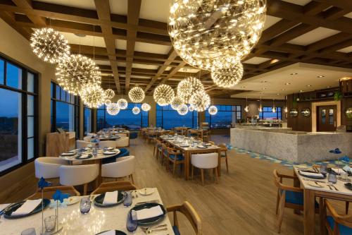 a dining room with tables and chandeliers at Vista Encantada Resort & Spa Residences, A La Carte All Inclusive Optional in Cabo San Lucas
