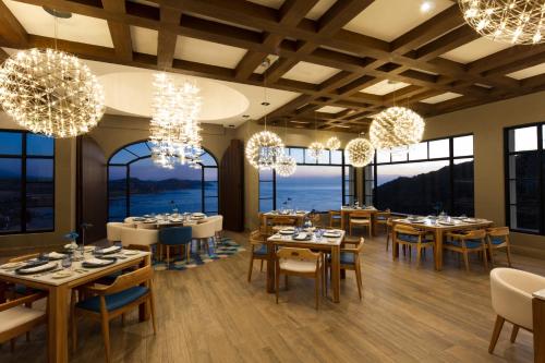 a dining room with tables and chairs and windows at Vista Encantada Resort & Spa Residences, A La Carte All Inclusive Optional in Cabo San Lucas