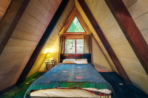a bed in a room with a large window at Under The Trees in Camp Connell