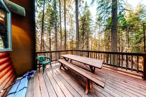 a wooden deck with a bench on the side of a house at Under The Trees in Camp Connell